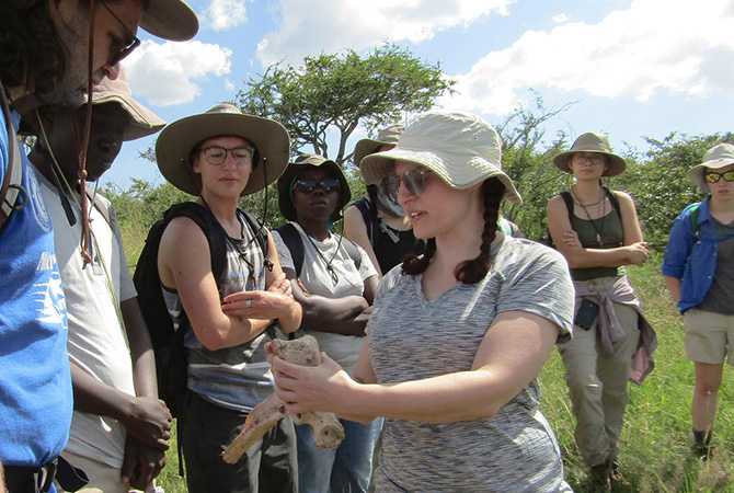 Frances Forrest at work in the field, displays a specimen to science students.