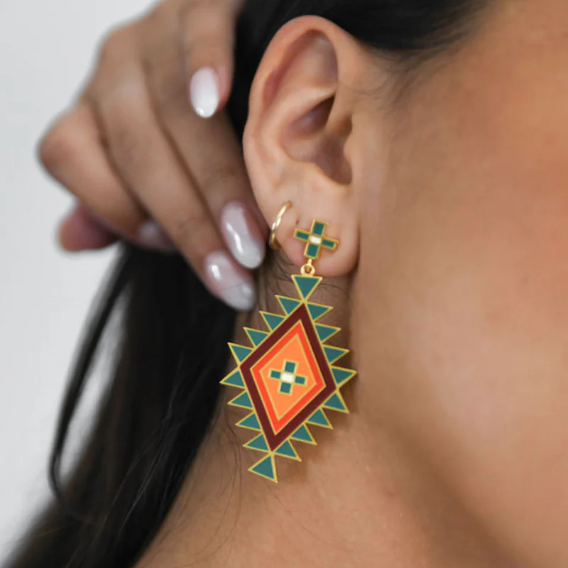 Photo of a green, orange, yellow, and green earring on a woman's ear.