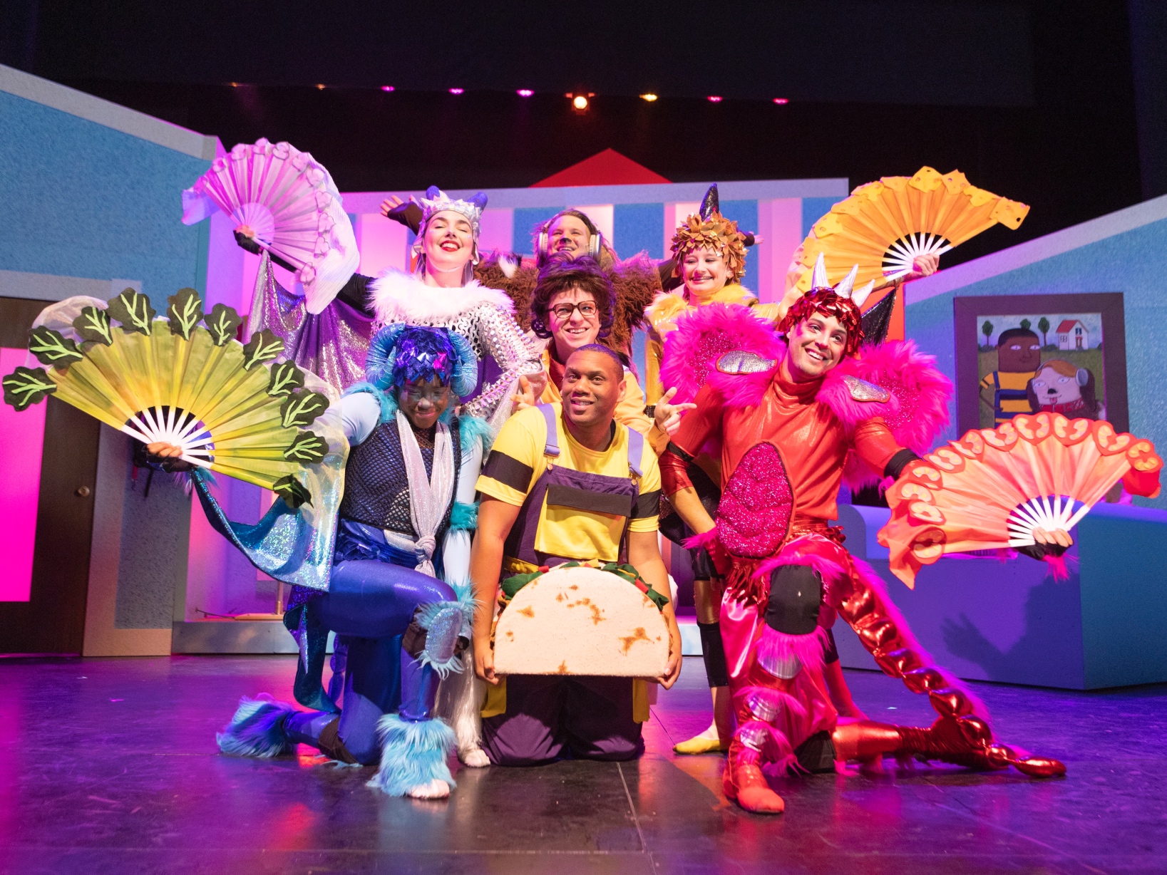 Photo of the cast of Dragons Love Tacos on stage in costume posing and smiling.