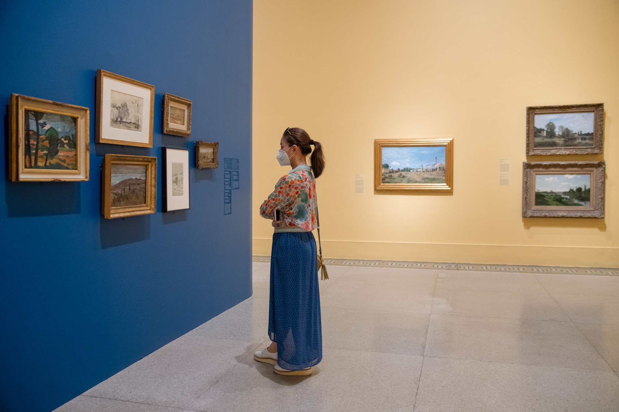 A visitor looks at paintings in the Brooklyn Museum