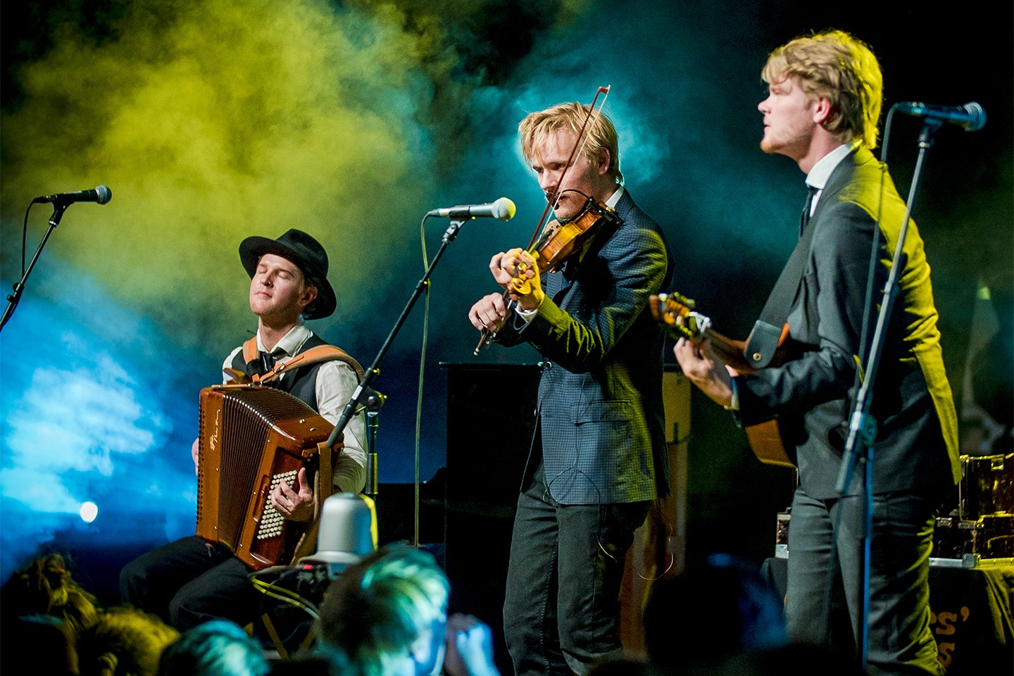 Dreamers' Circus performing on stage. Left to right: Nikolaj Busk plays the accordian, Rune Tonsgaard Sørensen plays the violin, and Ale Carr plays the Nordic cittern.