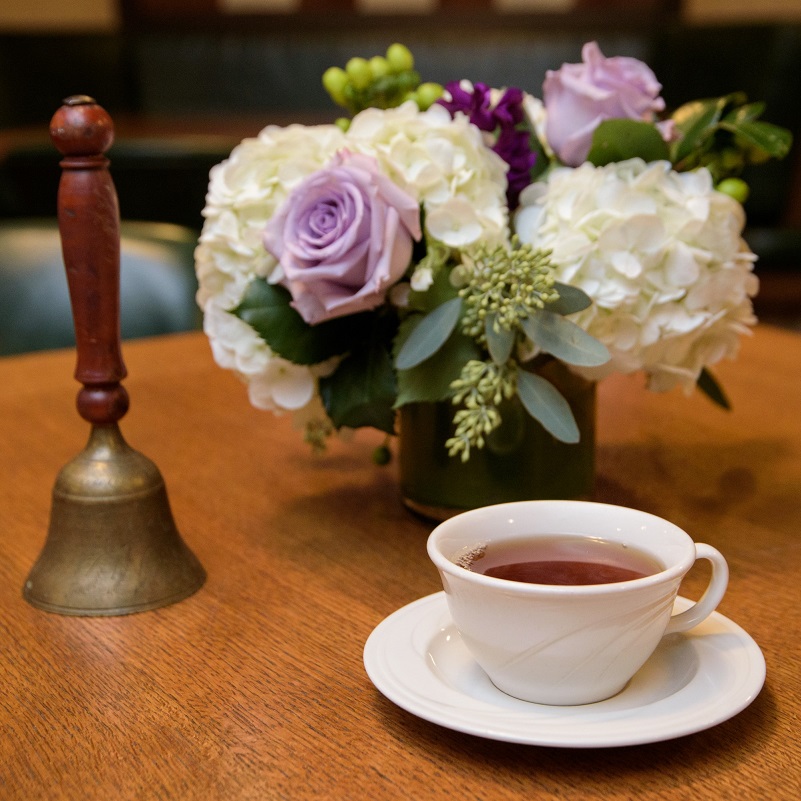 Tea cup, bell, and flower arrangement 