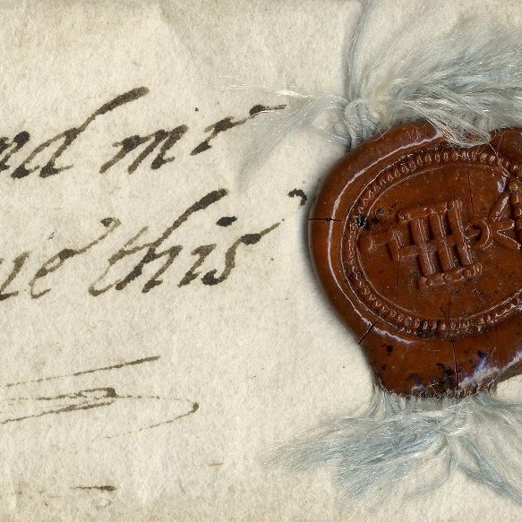 Early modern handwriting next to a red, stamped wax seal