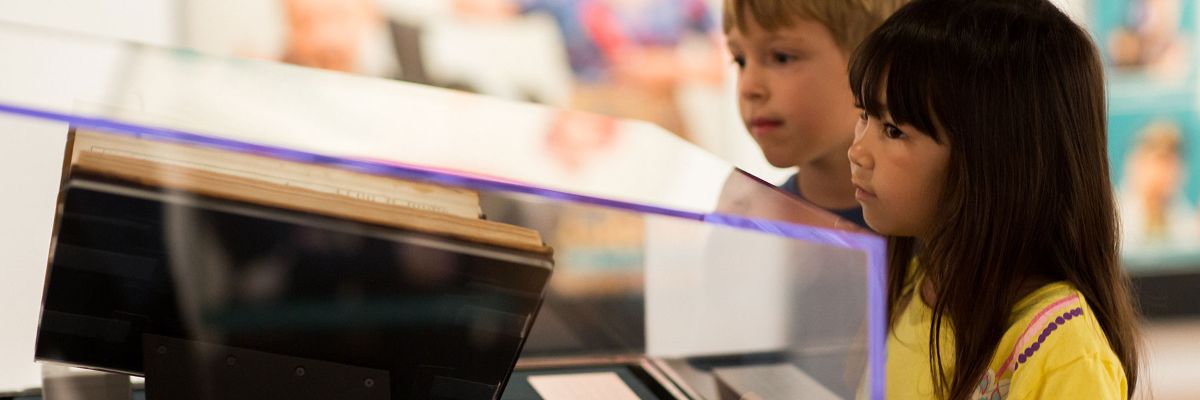 two children looking at a First Folio in a glass exhibition case