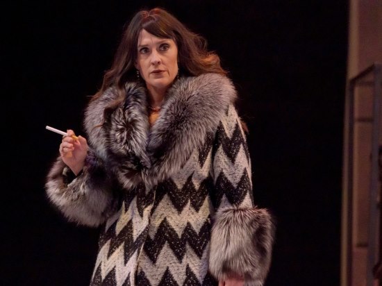 a woman in an eye-catching fur coat holding a cigarette