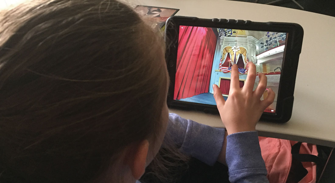 A student explores the Presidential Box in a virtual tour of Fords Theatre on an iPad. 