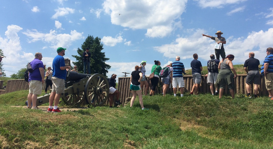 24 teachers standing in a battlefield. A National Park Service Ranger points afar, telling the story of the battle. 