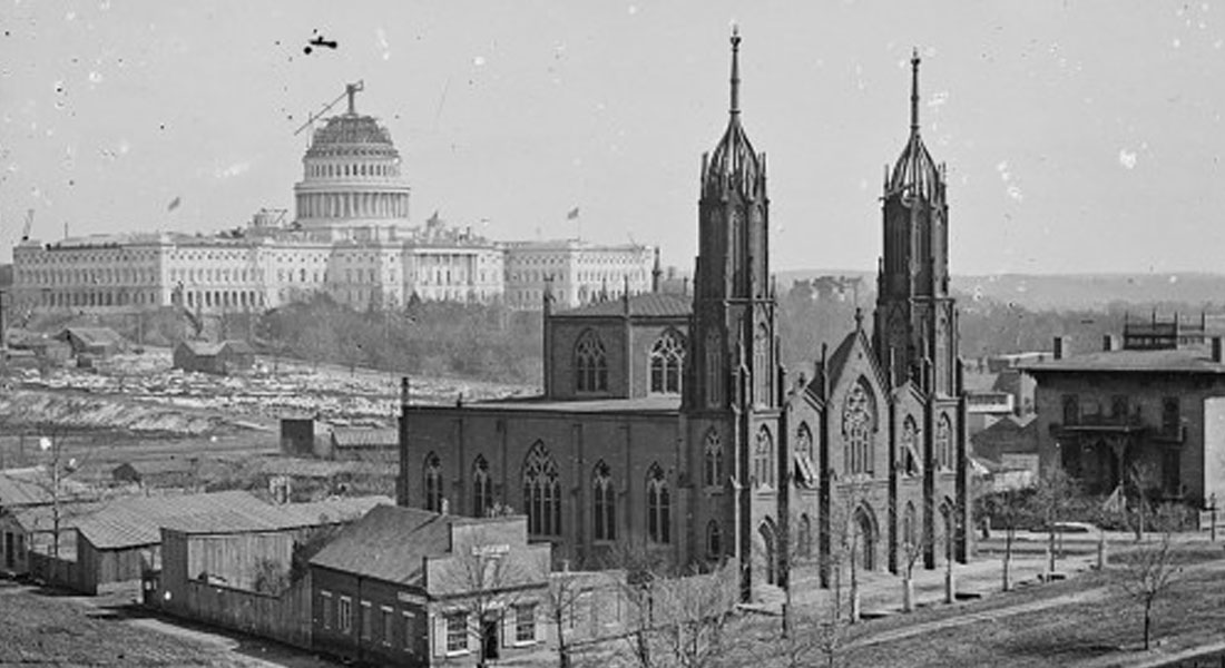 A black-and-white photograph showing Trinity Episcopal Church at Third and Indiana Avenue and an unfinished Capitol in the background. Link to distance-learning info.