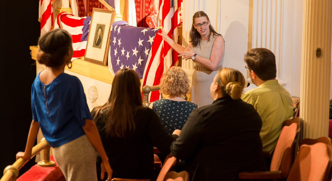 Photo of a tour guide and visitors viewing the Presidential Booth at Ford's Theatre by Gary Erskine. Link to Get tickets.