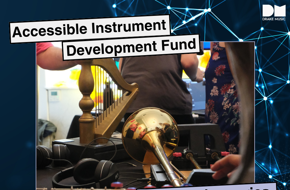 A variety of musical instruments including a small harp and trumpet are placed on a table. People in the background are using recording gear including a computer and headphones to record the instruments