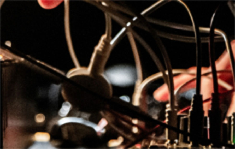 Hands are seen plugging wires into a mixing desk
