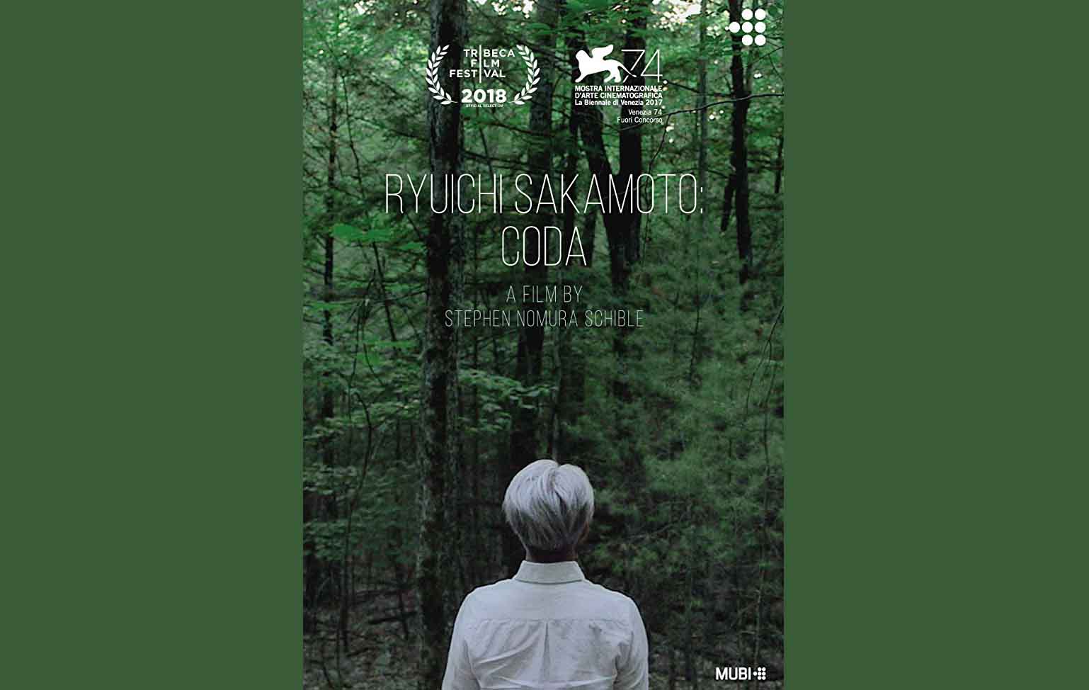 A lady is stood facing away from the camera looking at trees and woodland