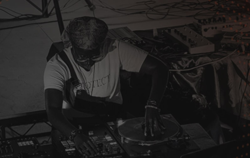 A young person is seen using DJ decks. They are wearing a white t shirt and glasses
