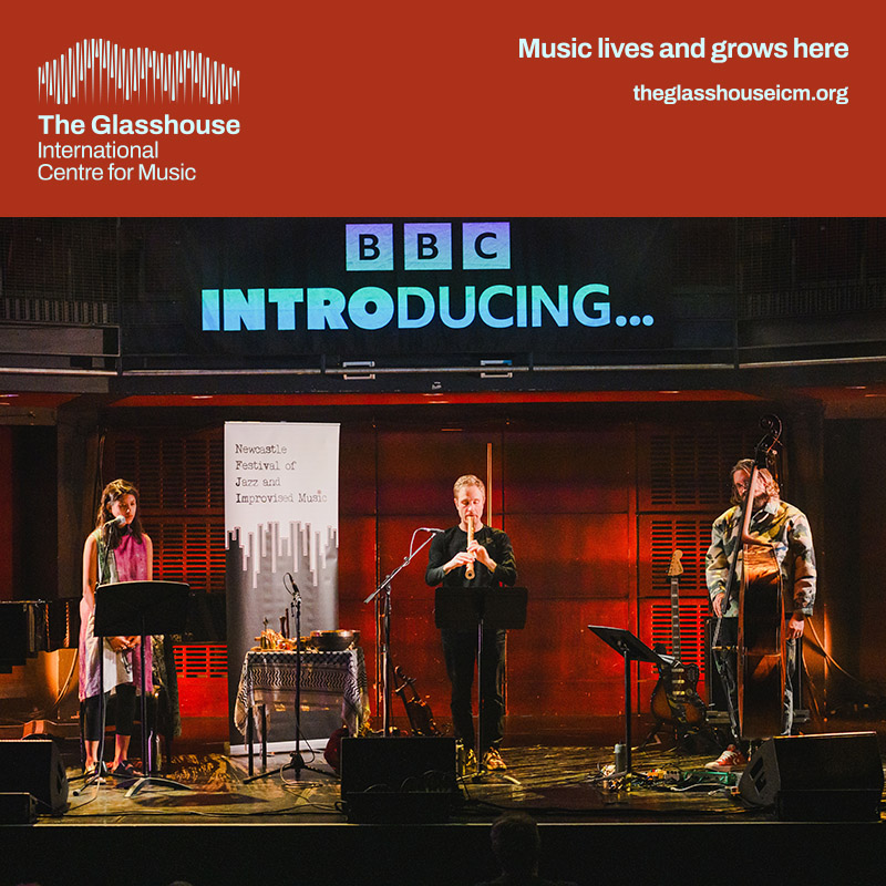 New Ways of Moving in the Counterworlds: three people are stood on stage, one lady singing into a microphone, one man playing a clarinet and the other stood next to a double bass