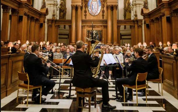 An orchestra is performing in front of an audience inside a church