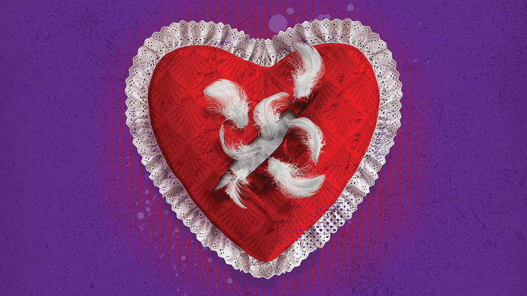 A red heart pillow with a white lace border ripping open in the middle with feathers escaping on a purple background