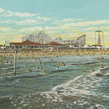 A postcard illustration of Pontchartrain Beach from 1931. Hundreds of people swim on the beach with roller coasters and other amusement park rides visible in the distance.