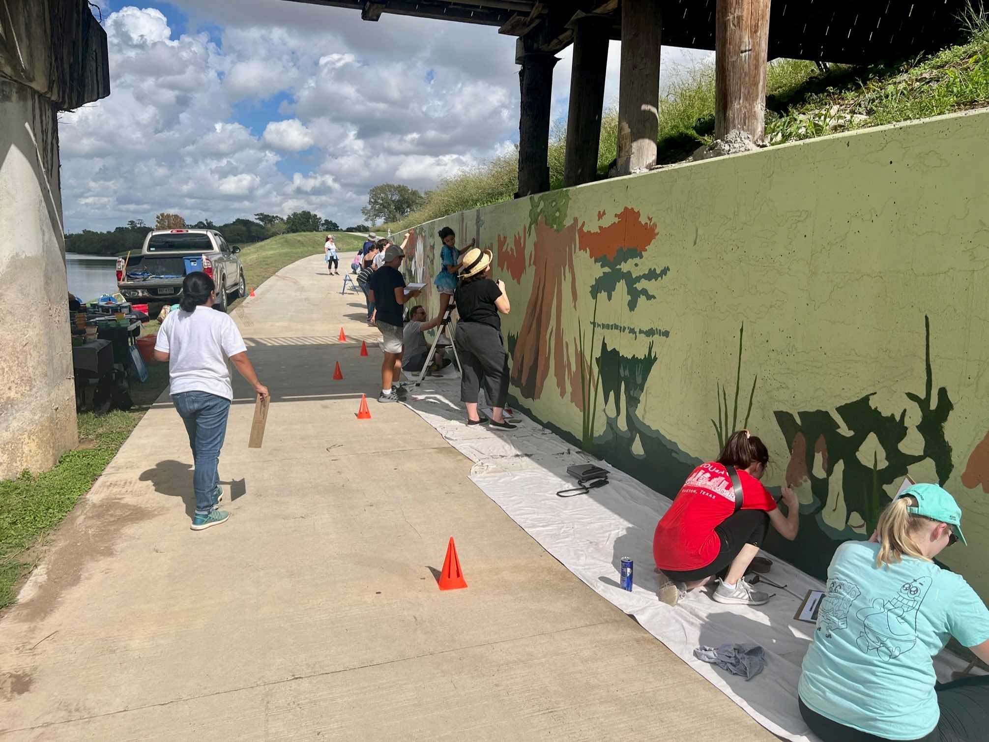 Volunteers work together to paint a mural. 