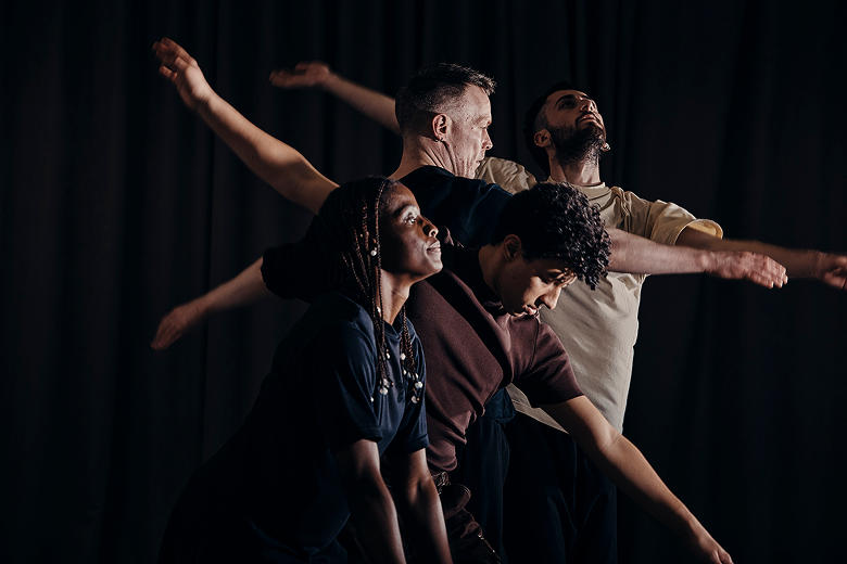 A side profile of four dancers with outstretched arms.