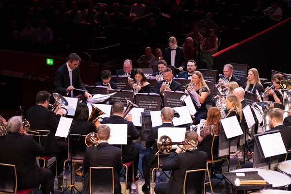 Members of the Flowers Band in black concert dress mid-performance.