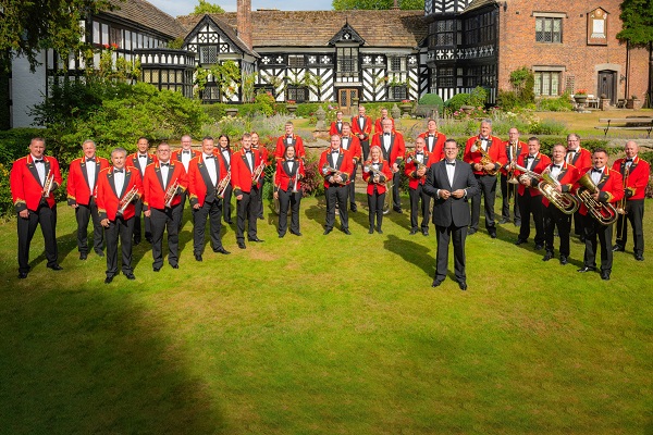 Members of the Foden's Band brass band in red concert dress with their instruments