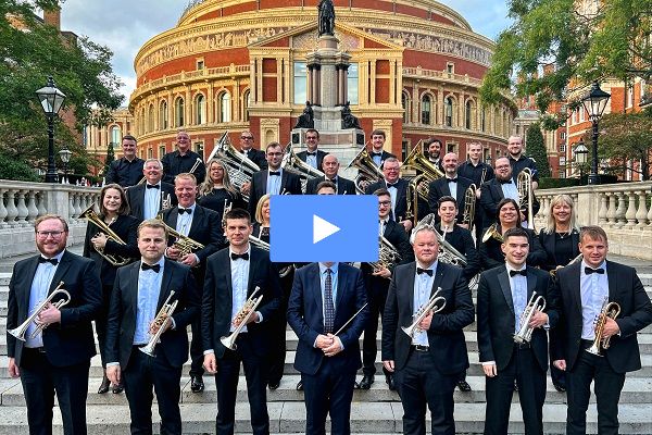 Members of the Rothwell Temperance Band in black concert dress with their instruments on the steps by the Royal Albert Hall.