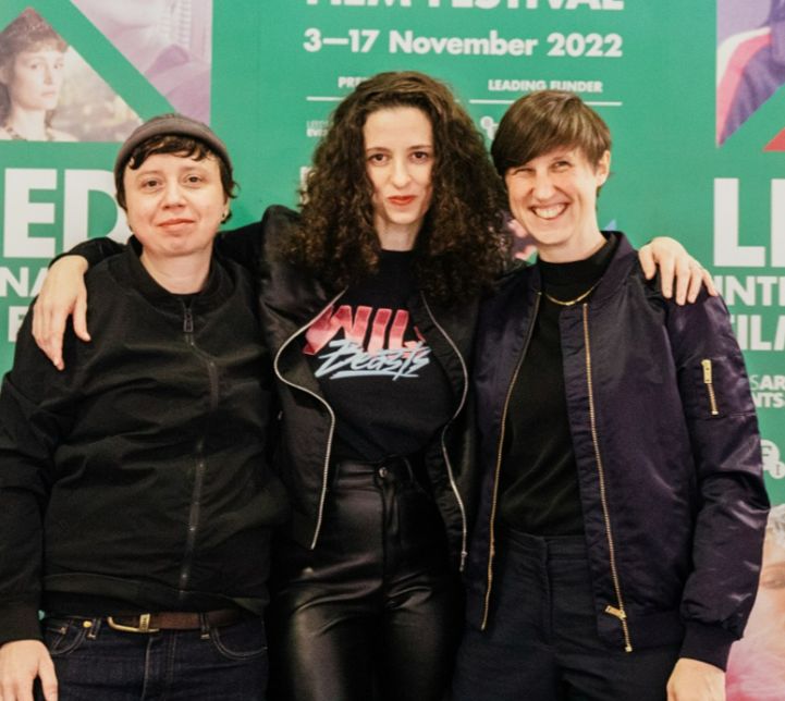 Three trendy young people post in front of the LIFF 2022 branding. 