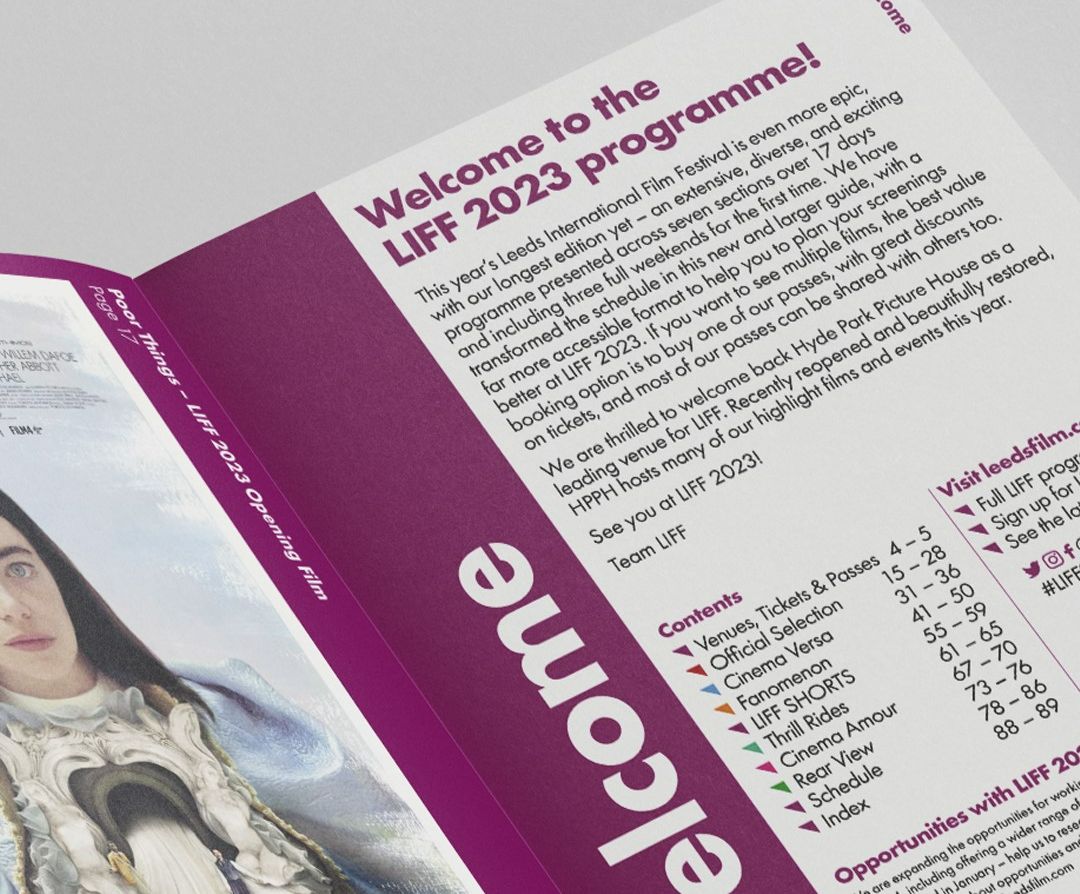 An image of the LIFF 2023 guide, a paper booklet decorated in purple and white. Opened on the "welcome" page.. 