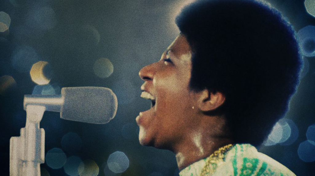 Aretha Franklin sings powerfully into a microphone.