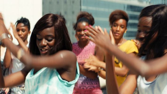 A group of young black women dance on top of a rooftop.