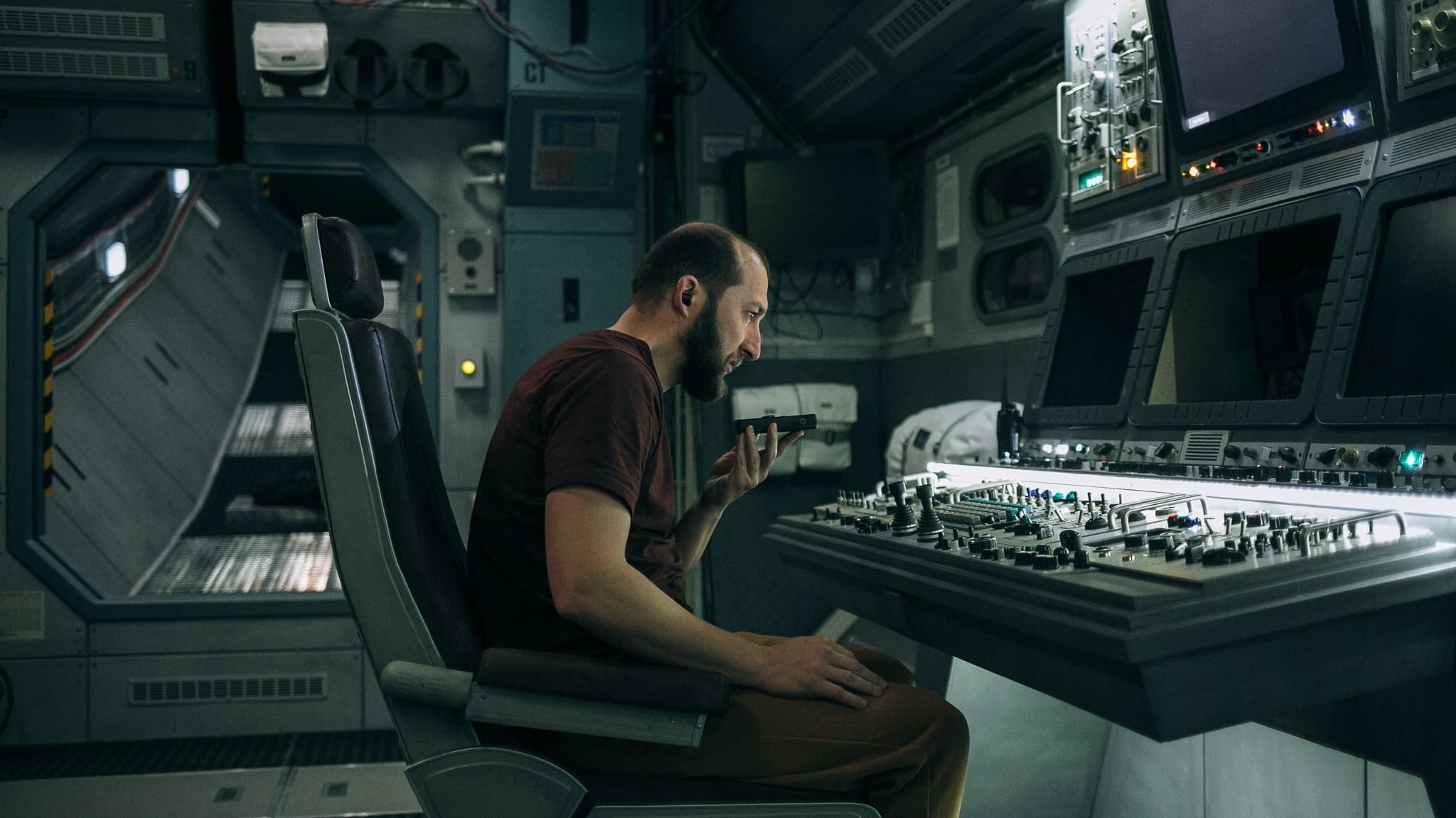 Still from U Are The Universe showing a man in a spaceship sitting at a control desk.