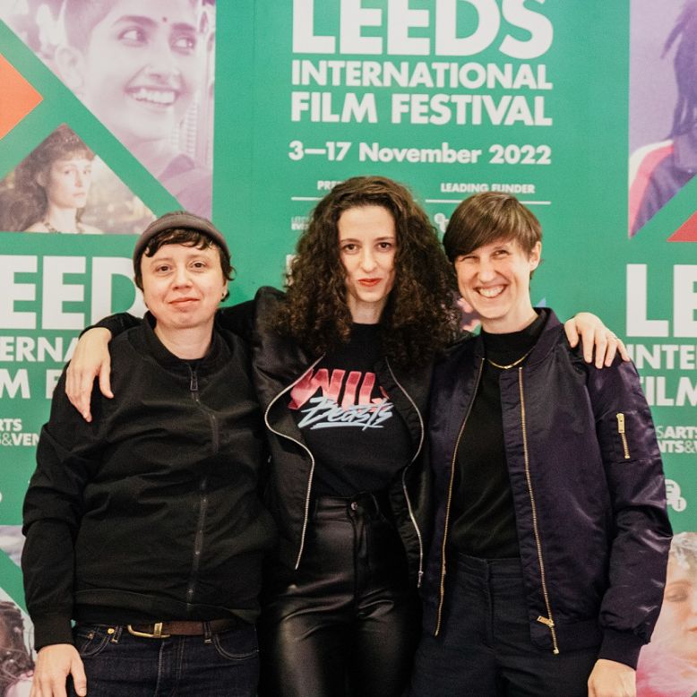 A group of women pose for the camera in front of a LIFF branded background.