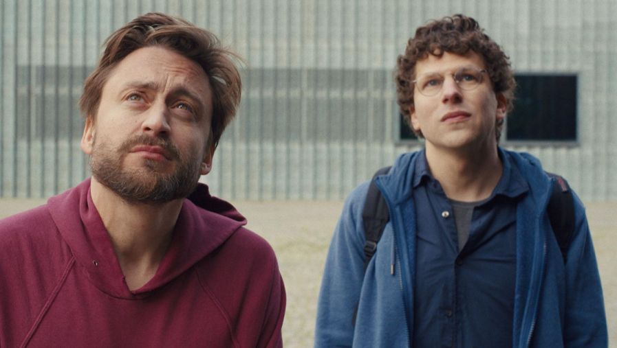 Two young men in casual clothes look up, slightly concerned.