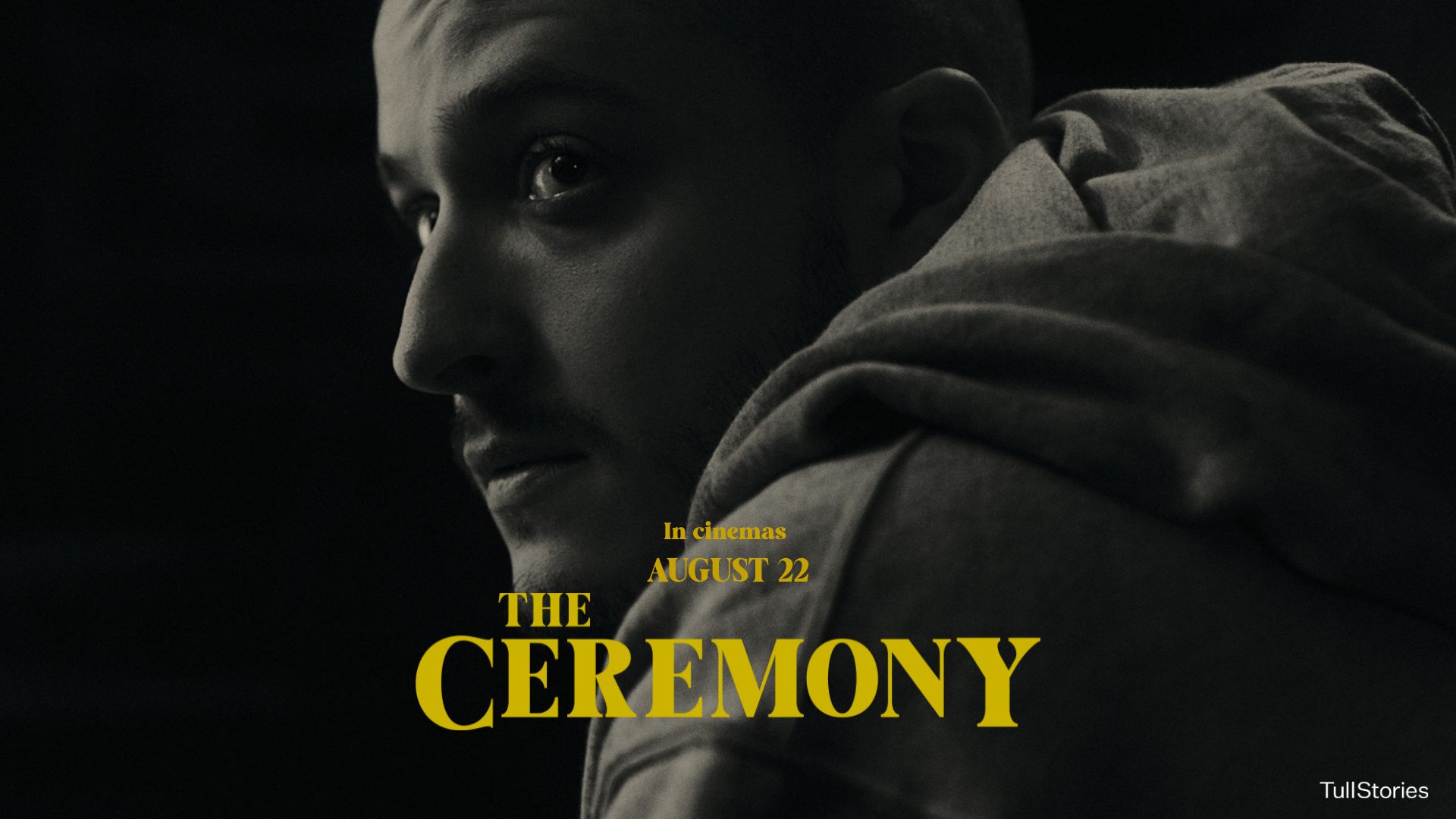 A moody black-and-white close-up of a man looking over his shoulder, with yellow text reading “The Ceremony – In cinemas August 22.”