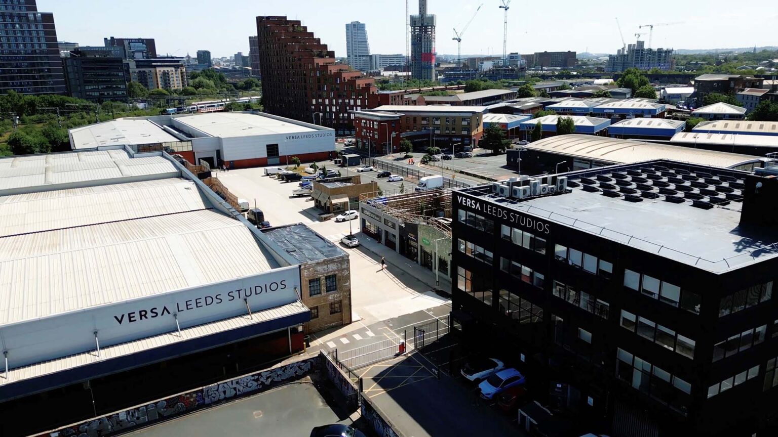 An aerial view of Versa Leeds Studios and surrounding industrial buildings, with the Leeds skyline visible in the background.