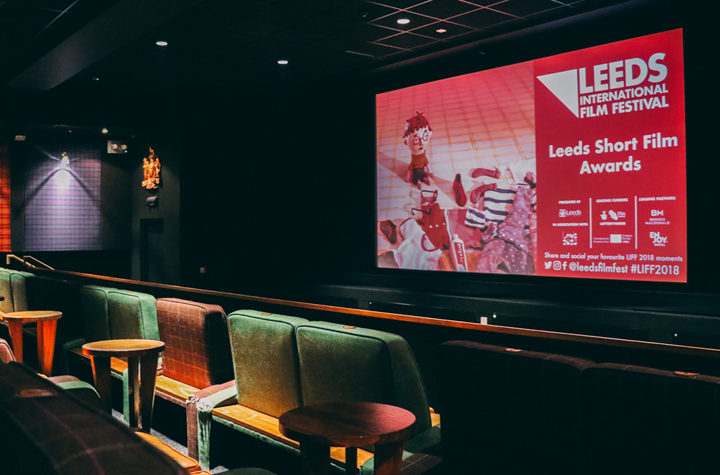 An empty cinema screen with a Leeds International Film Festival logo on the screen. 