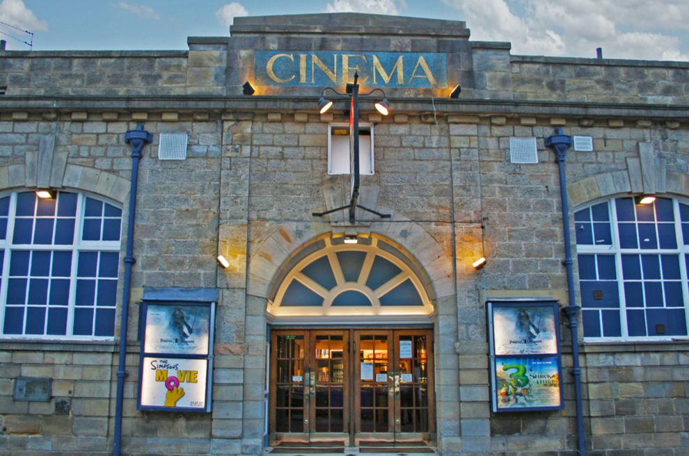 Photo of an old brick cinema with ornate windows. 