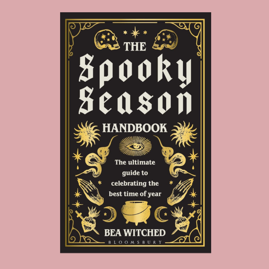 book called the spooky season handbook in gothic lettering with drawings of skulls