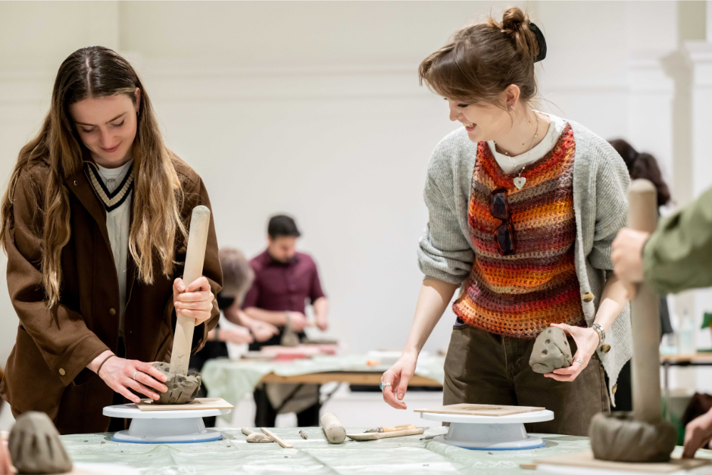two women sculpting with clay in central court at leeds art gallery
