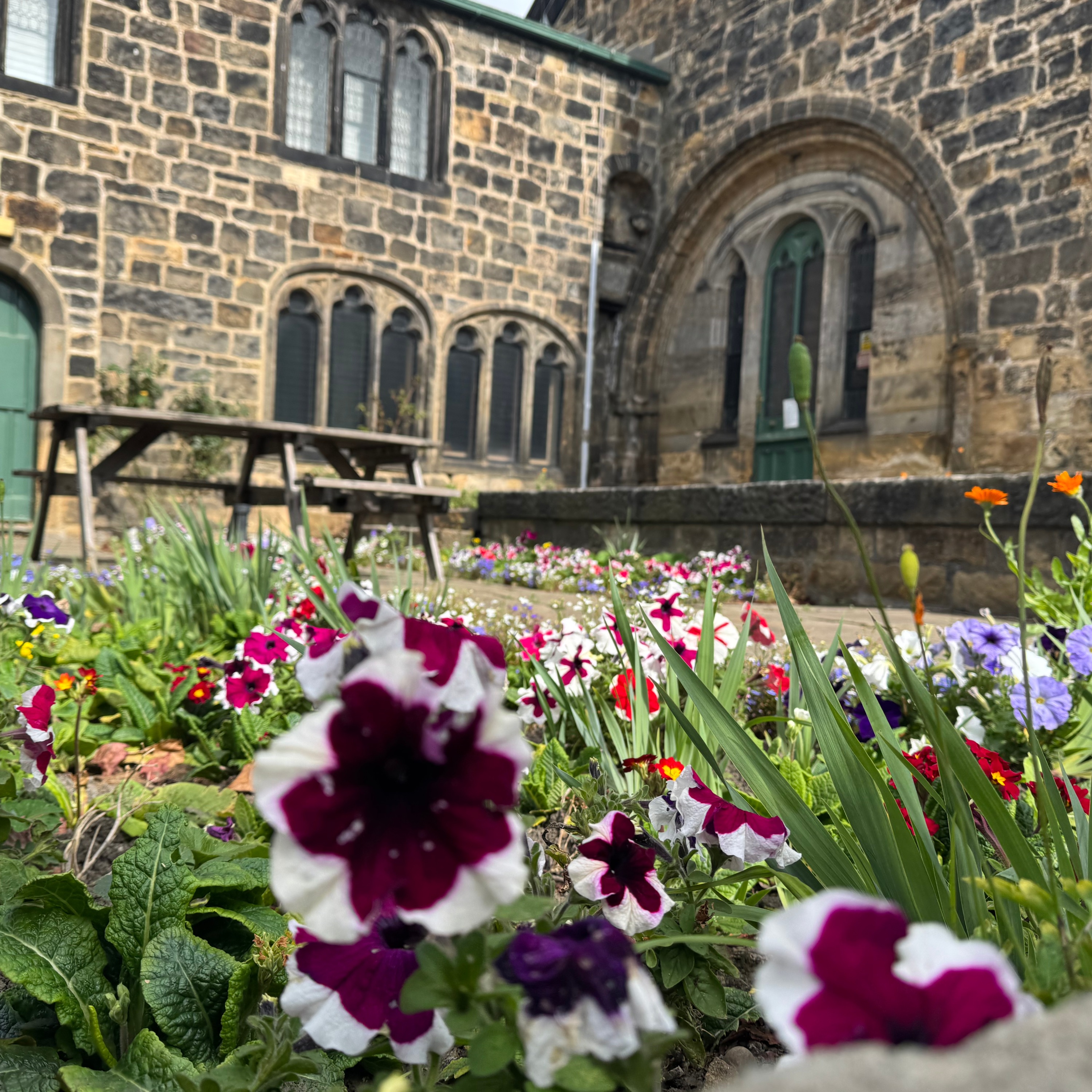 colourful flowers in the courtyard with exterior of Abbey House Museum in the background