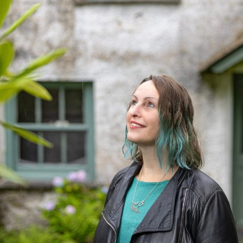 Portrait photo of author Polly Atkin wearing green top and black jacket