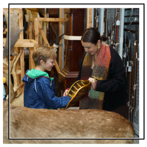 Child showing artwork to family and volunteers in artspace.