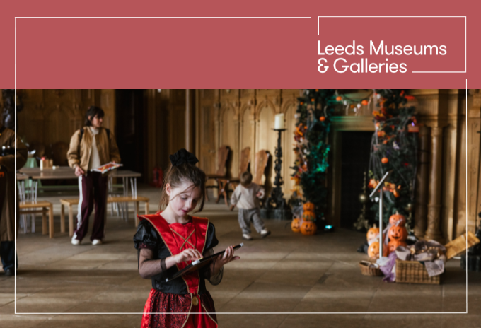 a child wearing a halloween costume and holding a clip board, in the great hall at temple newsam