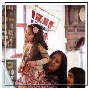 family in leeds industrial museum. mum is lifting the child up to look at something