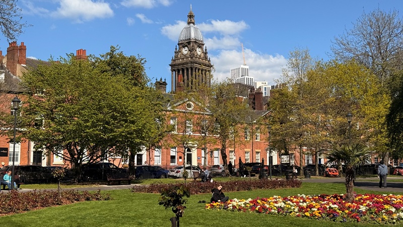 Leeds Town Hall in the sunshine overlooking Park Square with spring flowers in bloom.