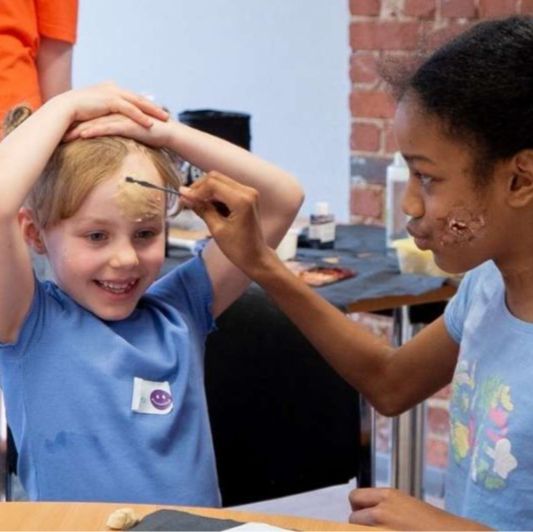 A picture from Movie Club at LYFF 2025 showing two girls painting each other's faces with special FX makeup.