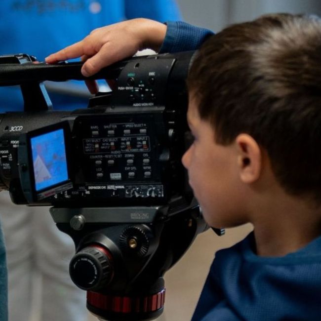 A picture from Movie Club at LYFF 2025 showing a small boy using a film camera.