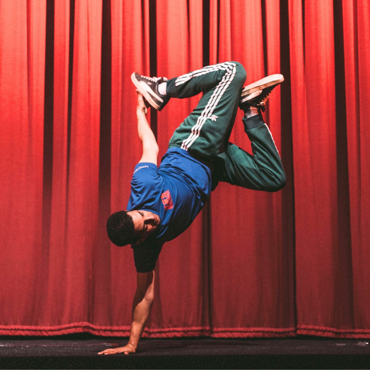 A photo showing a stunt display man posing on one arm with his legs in the air.