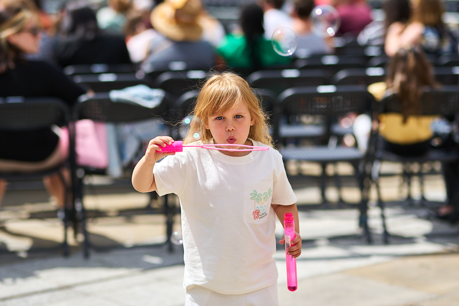 A little girl blows bubbles at Cinema on the Square