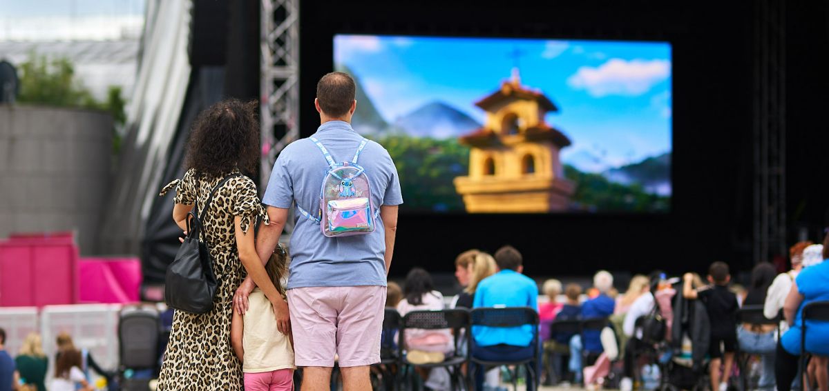 A family stand with their daughter watching Cinema on the Square